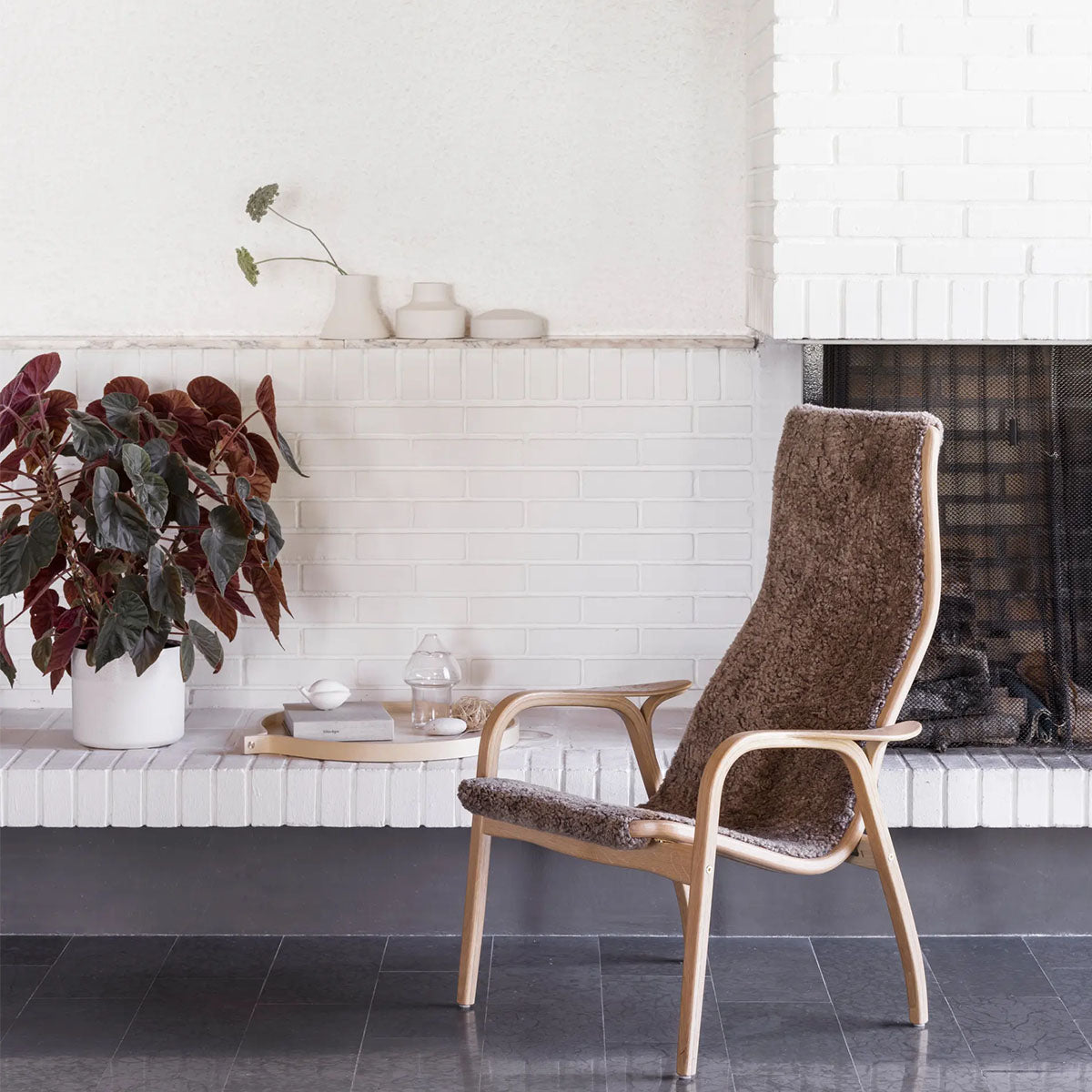 Lamino chair in sheepskin in  a living room with a fireplace.