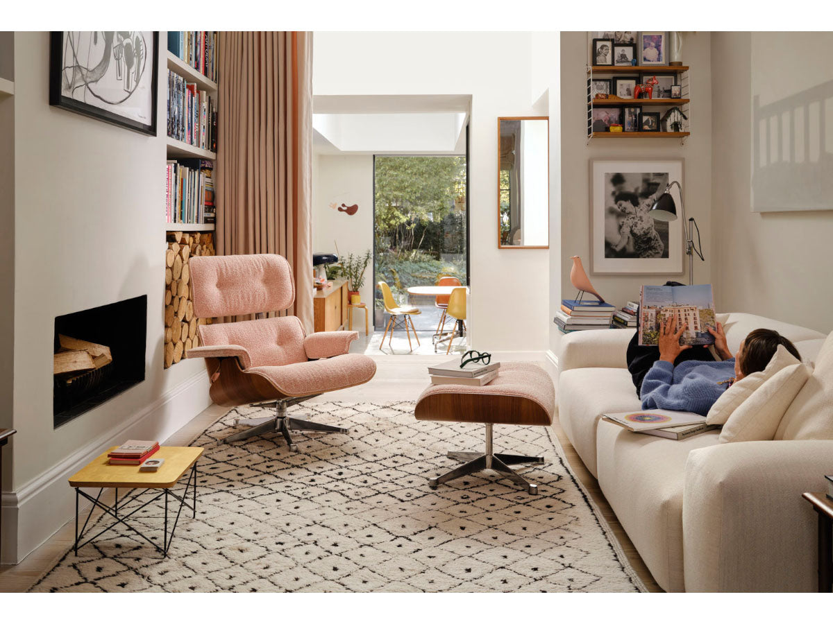 Vitra Eames Lounge Chair & Ottoman in fabric upholstery, featuring a wooden frame and a cushioned seat and backrest.