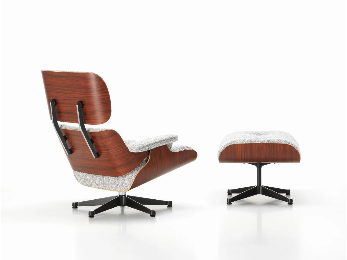A Vitra Eames Lounge Chair & Ottoman in fabric upholstery, featuring a wooden frame and a cushioned seat and backrest.